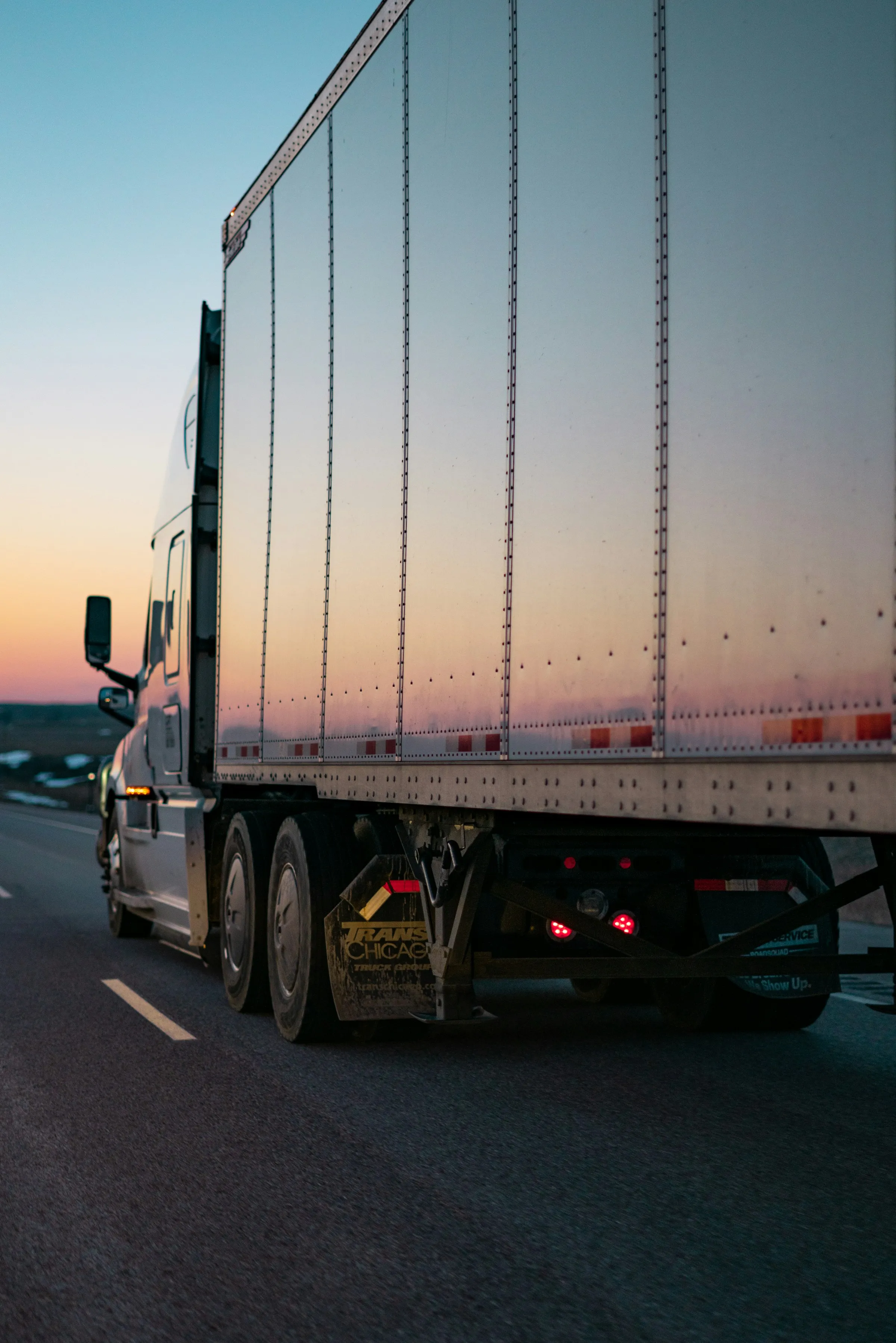 Un camión de carga en la carretera al atardecer